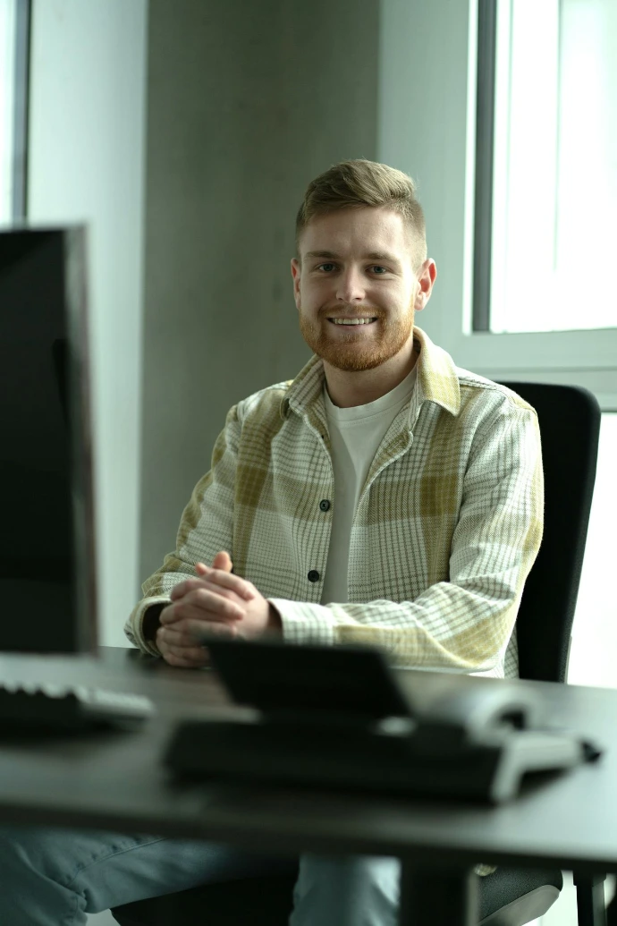 a man sitting at a desk in front of a computer